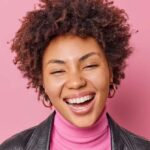 Mulher sorrindo sobre fundo rosa