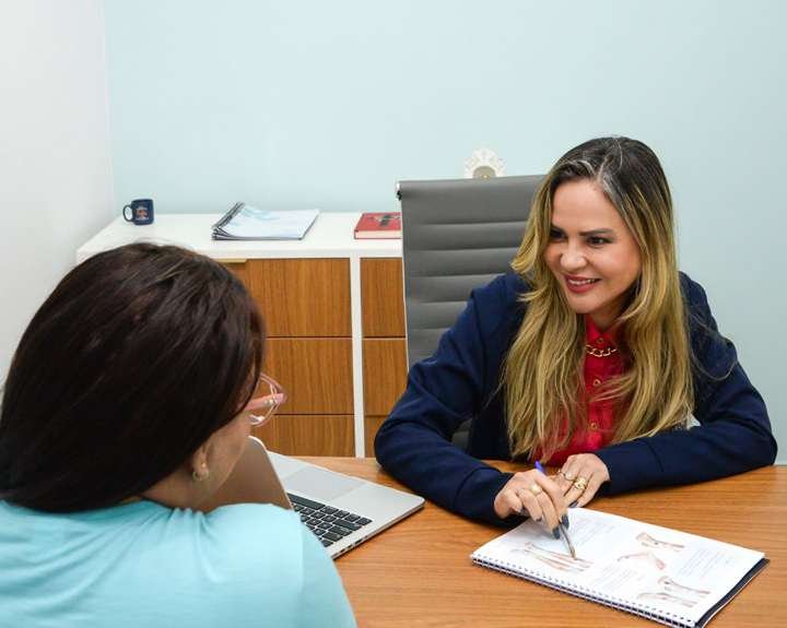 Profissional conversa com paciente em consultório