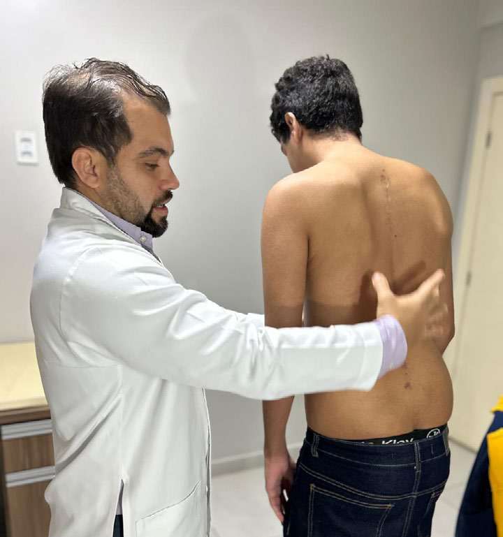 Médico examina as costas de um paciente