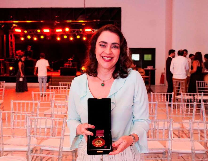 A secretária Débora Leite exibe a Medalha de Honra ao Mérito Odontológico