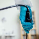 Mão com luva segurando aparelho de endoscopia