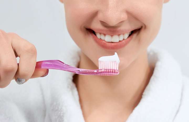 Mulher sorridente escovando os dentes