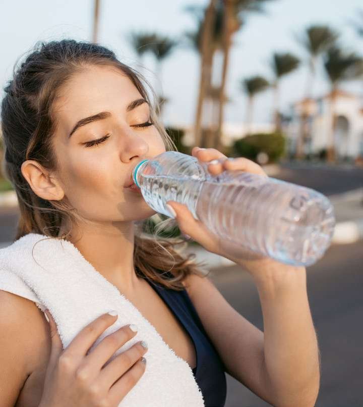 Mulher bebendo água de garrafa após exercício