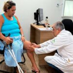 Ortopedista examina joelho de paciente no Ipesaúde