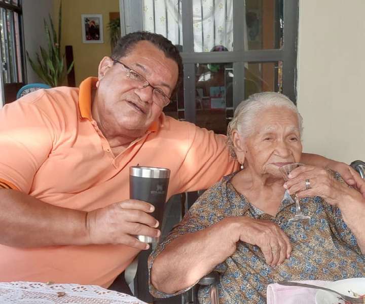 Dr. José Augusto sentado ao lado da mãe idosa, Dona Maria José