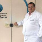 Dr. José Augusto Santos da Silva diante da placa do Serviço de Cirurgia Bucomaxilofacial