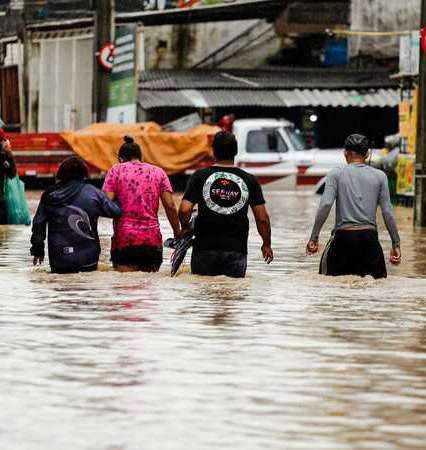 Pessoas caminhando em rua alagada