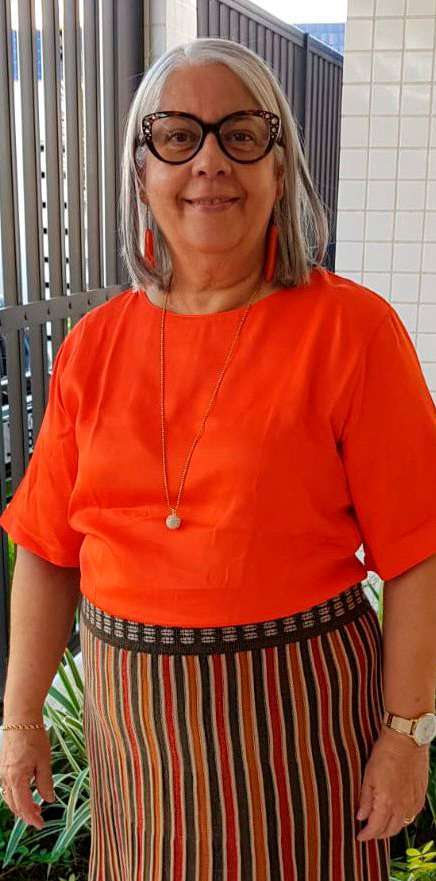 Marlene Alves Calumby sorrindo, de blusa laranja