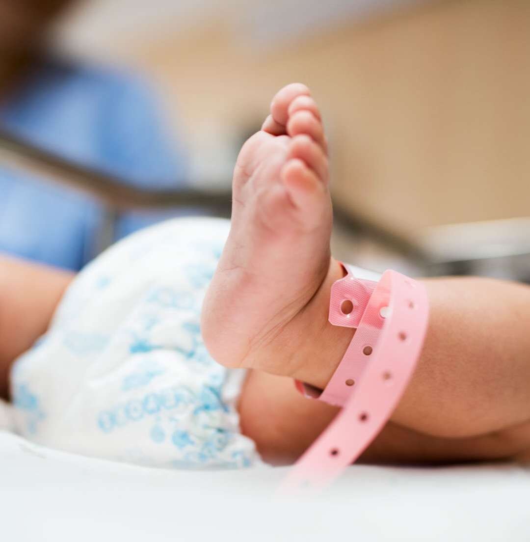 Pé de bebê recém-nascido com pulseira de identificação