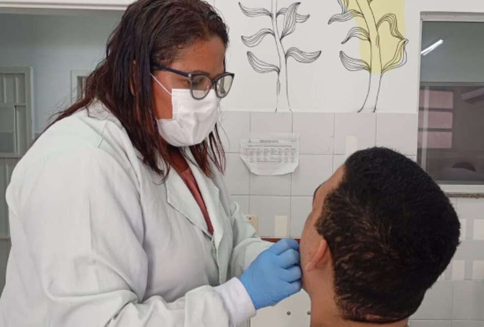 Cirurgiã-dentista examina a boca de paciente no hospital