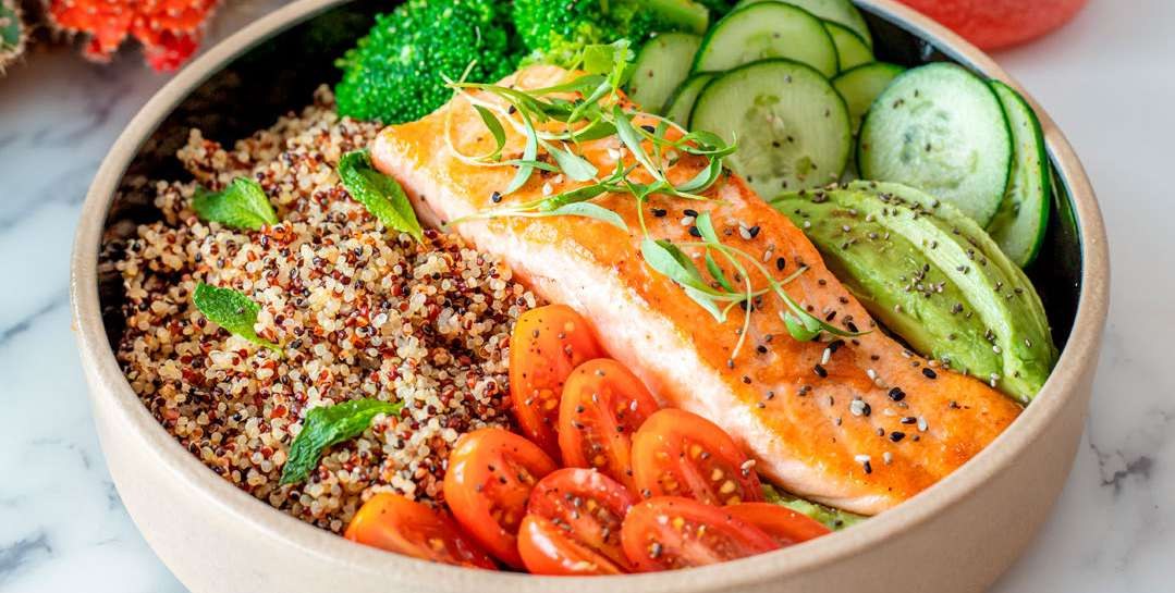 Prato com salmão, grãos e legumes frescos