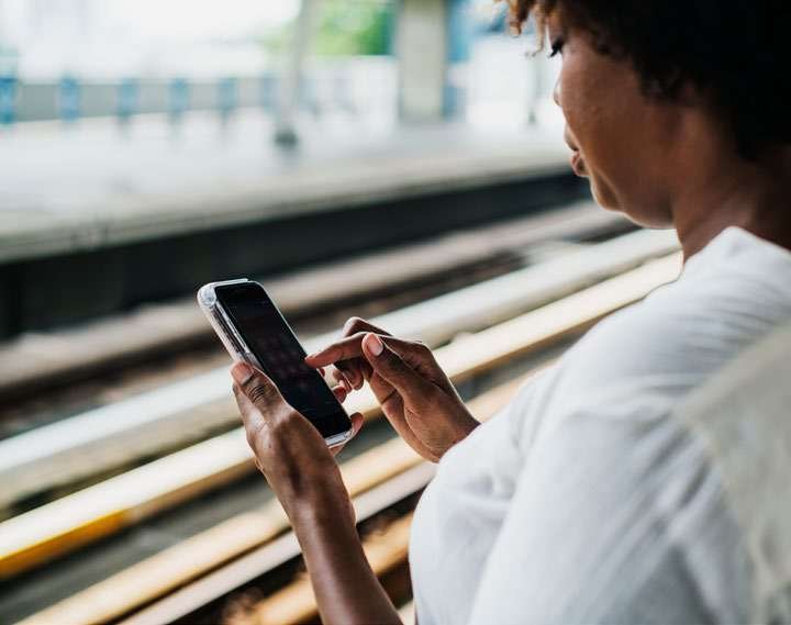 Mulher usando celular em estação