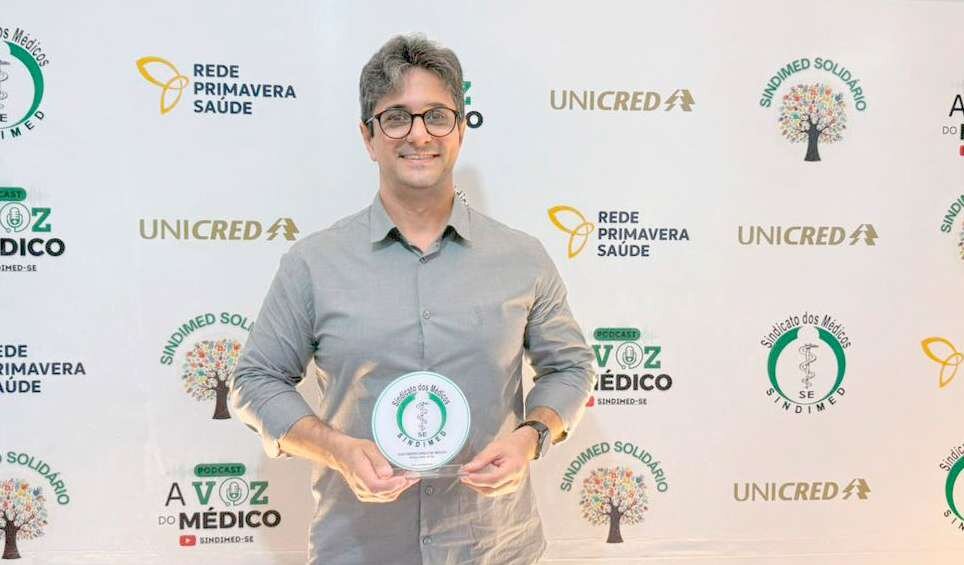Homem segura o troféu do Prêmio Amigo do Médico, do Sindimed