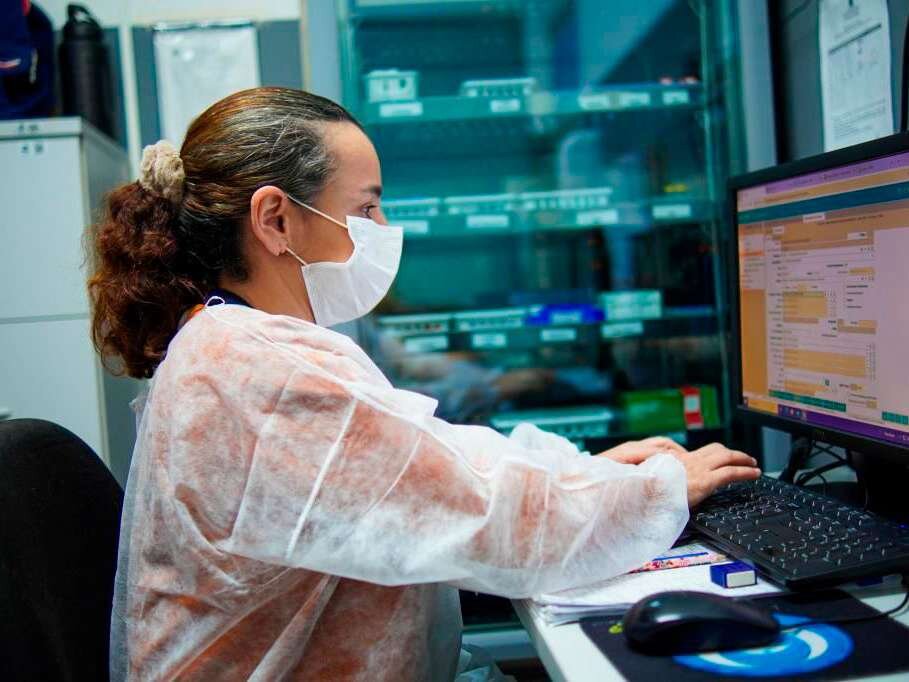 Profissional de saúde trabalha em computador em unidade de saúde