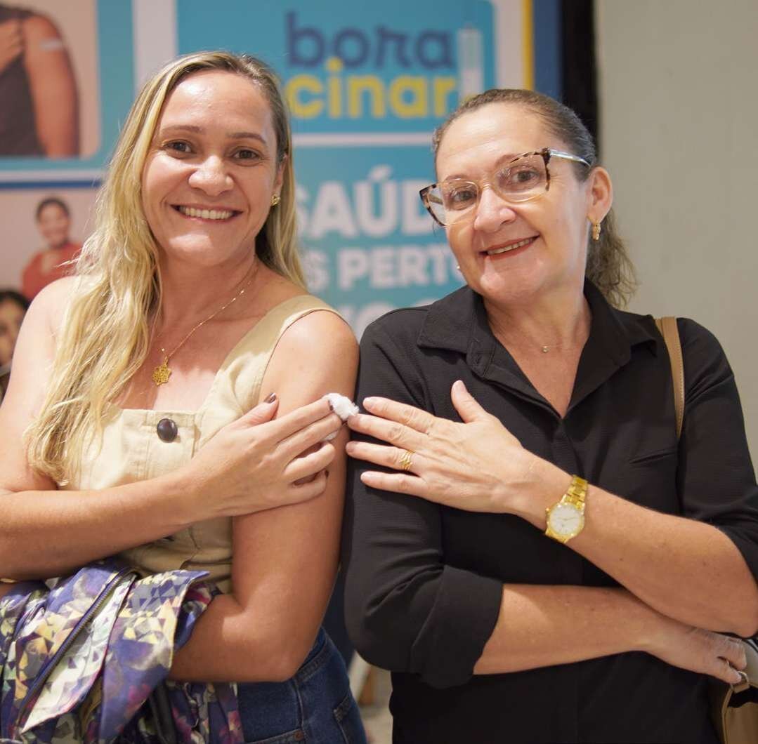 Mulheres mostram o braço após serem vacinadas