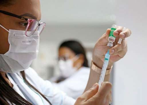 Profissional de saúde prepara seringa para vacinação
