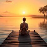 Pessoa meditando em píer ao pôr do sol