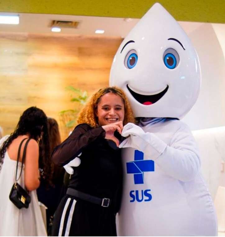 Mulher posa com o Zé Gotinha em ação de vacinação